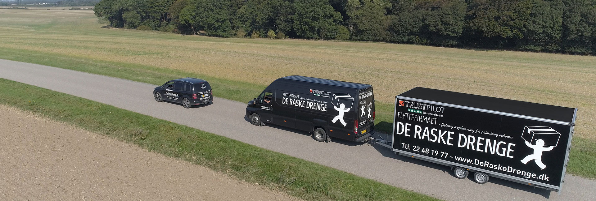 Personbil og varevogn med trailer tilhørende flyttefirmaet De Raske Drenge